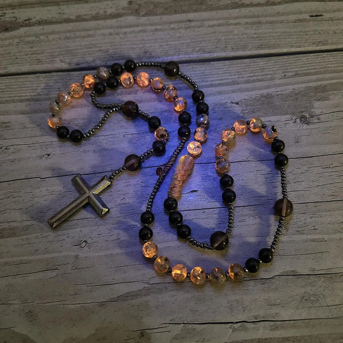 Acest colier rozariu este realizat din obsidian natural și euphorbie, un cristal vindecător cu energie protectoare ce reacționează la lumina ultravioletă.