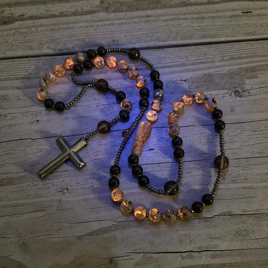Acest colier rozariu este realizat din obsidian natural și euphorbie, un cristal vindecător cu energie protectoare ce reacționează la lumina ultravioletă.